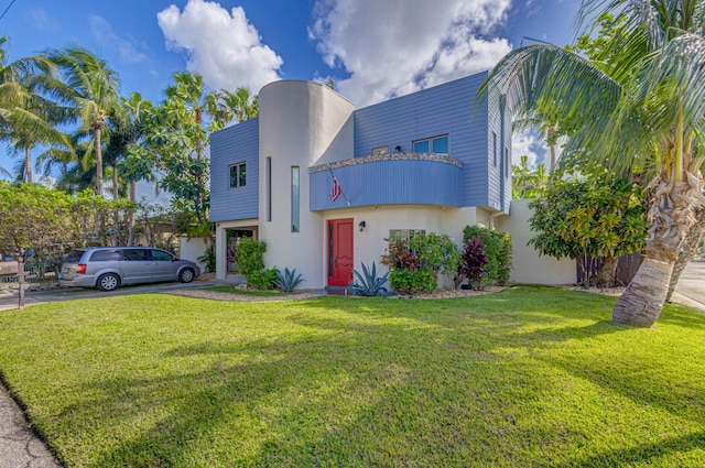 view of front of property with a front yard and a balcony