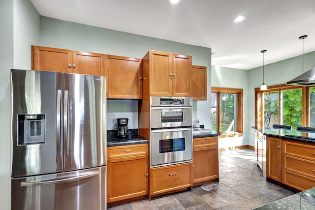 kitchen with appliances with stainless steel finishes, decorative light fixtures, and dark stone countertops