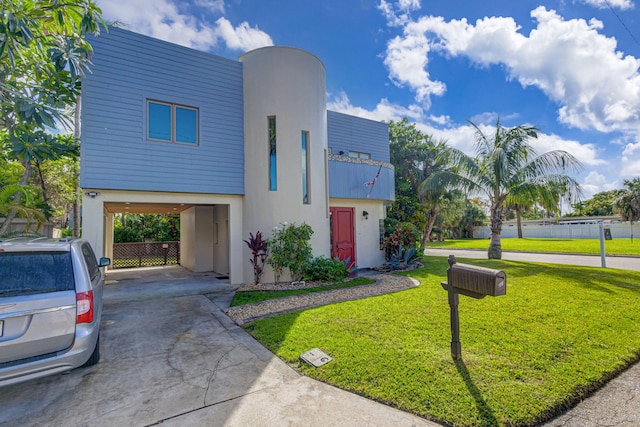 view of front of property featuring a front lawn and a carport