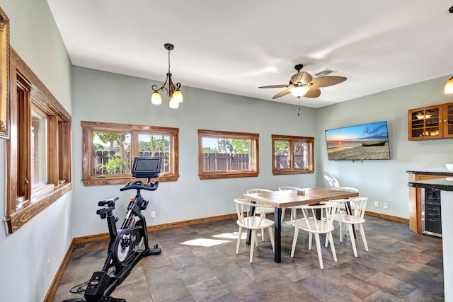 dining area featuring wine cooler and ceiling fan with notable chandelier