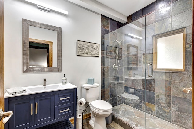 bathroom featuring toilet, a shower with shower door, and vanity