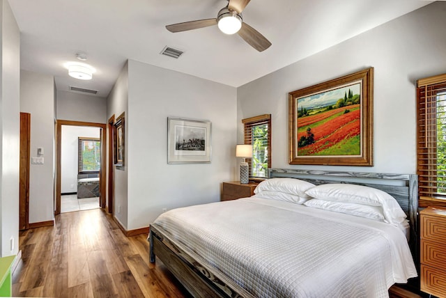 bedroom with ceiling fan, multiple windows, and hardwood / wood-style floors