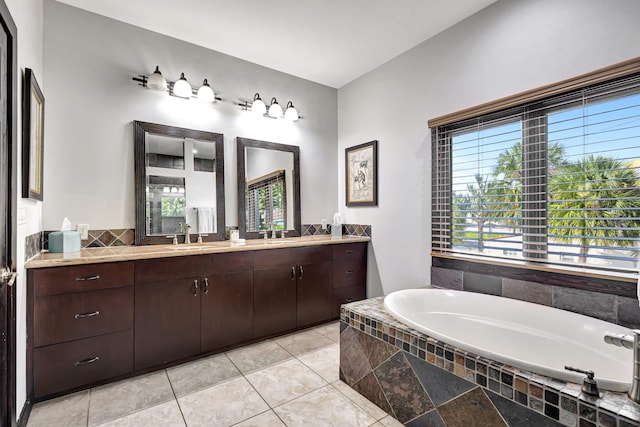 bathroom featuring vanity, a relaxing tiled tub, and tile patterned floors