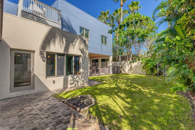 view of yard with a balcony and a patio