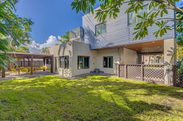 rear view of house featuring a patio and a lawn