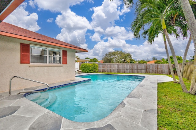 view of swimming pool with a yard