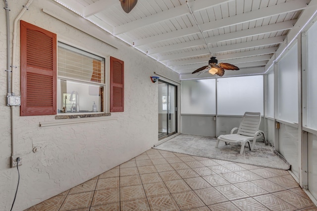 unfurnished sunroom with beamed ceiling and ceiling fan