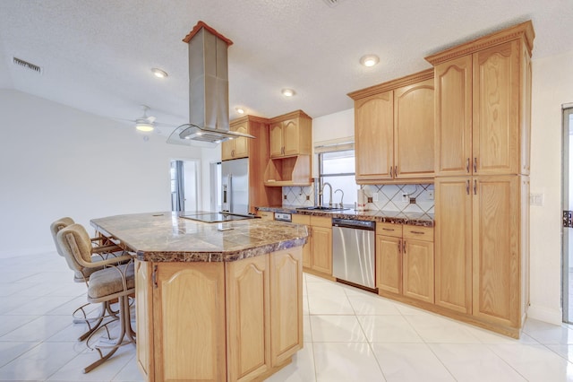 kitchen featuring tasteful backsplash, light brown cabinetry, sink, a kitchen island, and stainless steel appliances