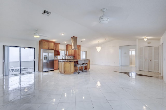 kitchen with lofted ceiling, stainless steel fridge, pendant lighting, light tile patterned floors, and ceiling fan