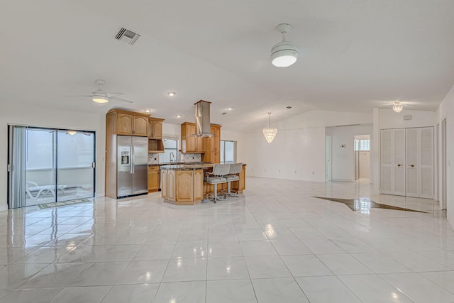 kitchen featuring a center island, hanging light fixtures, lofted ceiling, light tile patterned floors, and stainless steel refrigerator with ice dispenser