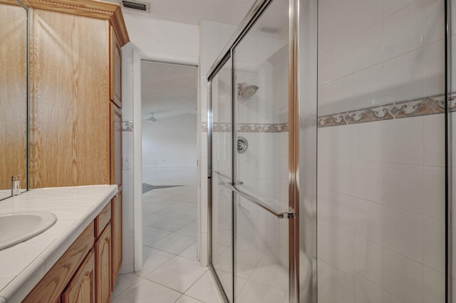 bathroom with vanity, a shower with shower door, and tile patterned floors