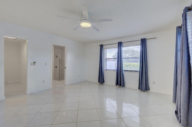 spare room featuring ceiling fan and light tile patterned floors