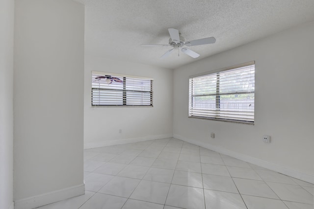 spare room featuring ceiling fan, a textured ceiling, and light tile patterned flooring