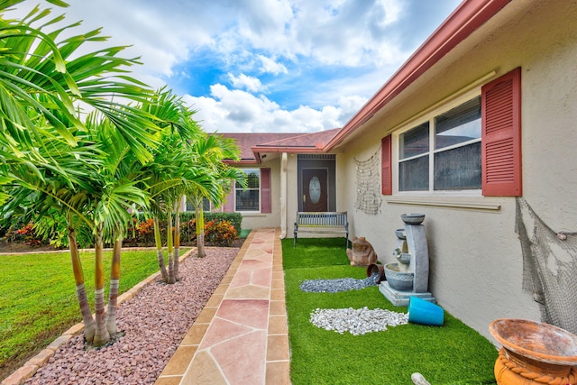 entrance to property with a lawn