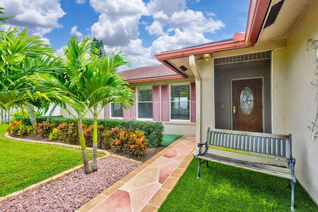 view of exterior entry with a yard