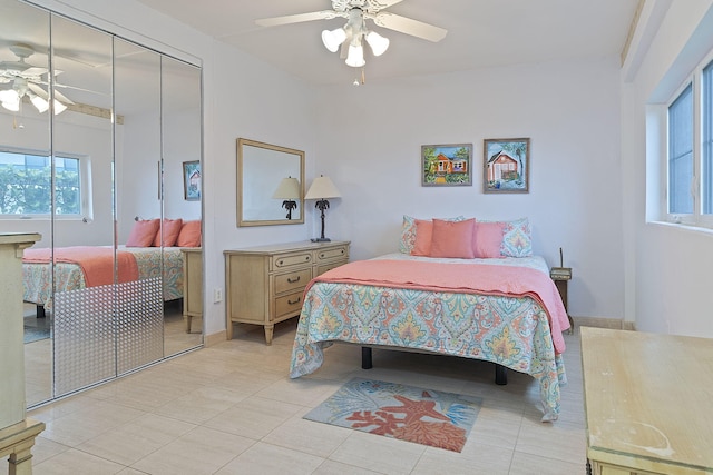 tiled bedroom with ceiling fan and a closet