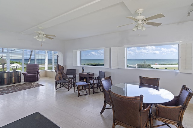 dining room featuring ceiling fan, a healthy amount of sunlight, and a water view