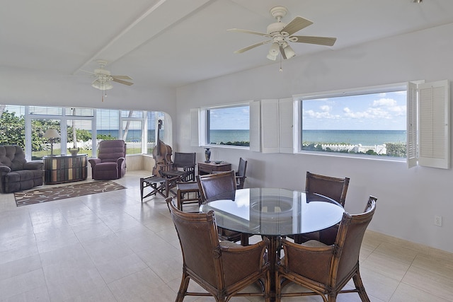 dining space featuring ceiling fan, a water view, and light tile patterned flooring