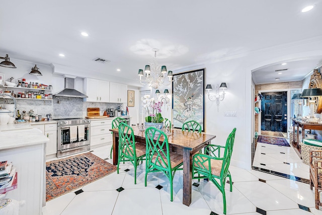 tiled dining room with ornamental molding and a chandelier