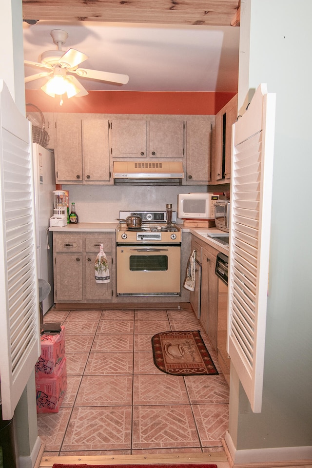 kitchen featuring stove, light tile patterned flooring, dishwasher, and ceiling fan