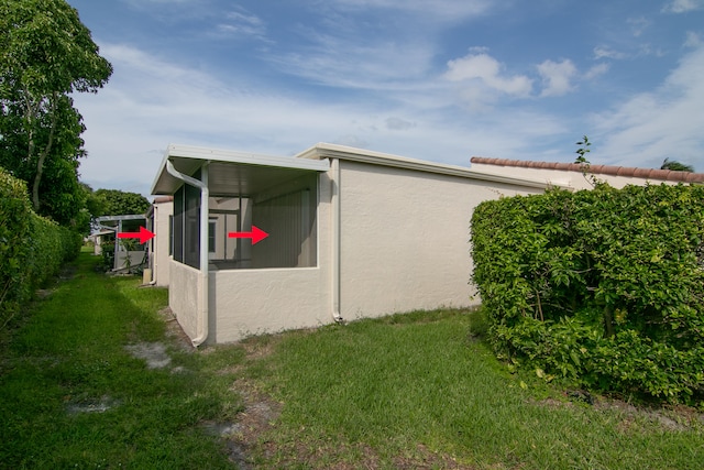 view of property exterior featuring a yard and a sunroom