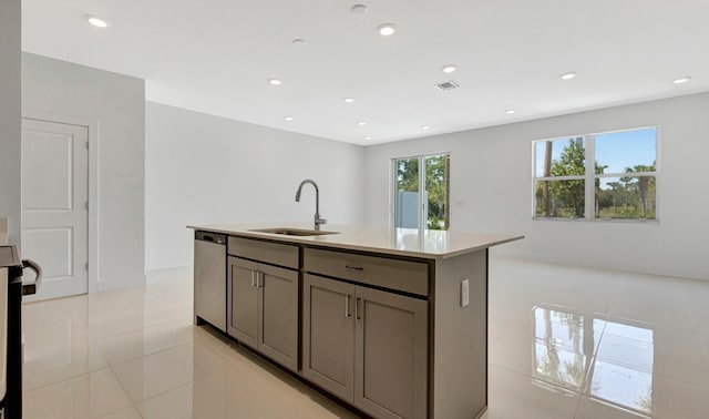 kitchen with a kitchen island with sink, stainless steel appliances, sink, light tile patterned flooring, and gray cabinets