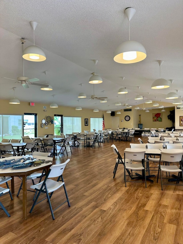 dining room featuring a textured ceiling, wood-type flooring, and ceiling fan