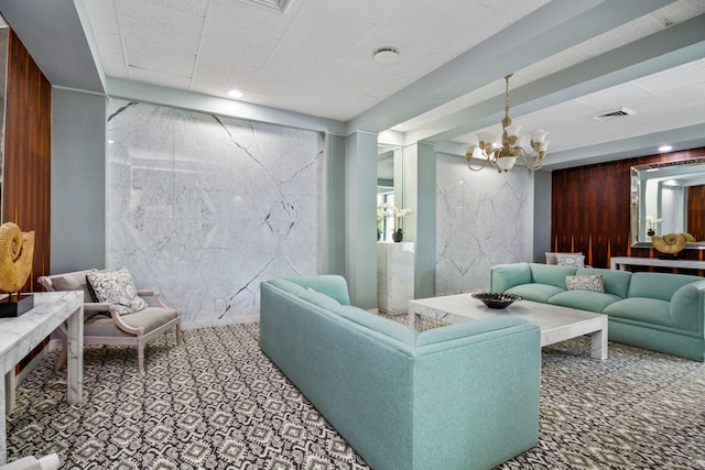 living room featuring carpet, a chandelier, and wooden walls