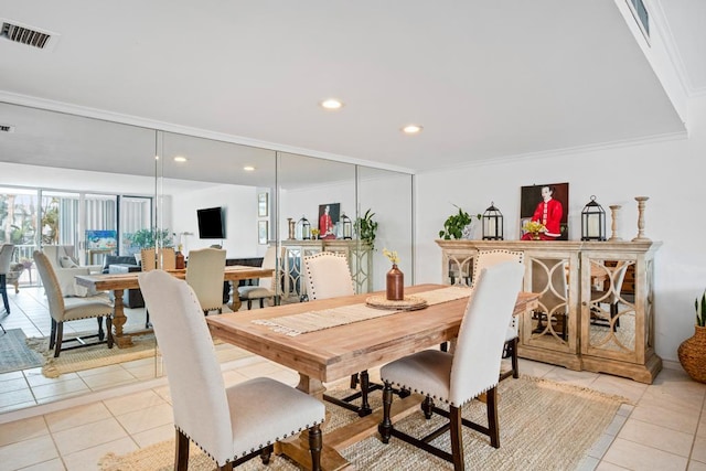 dining room featuring crown molding and light tile patterned floors