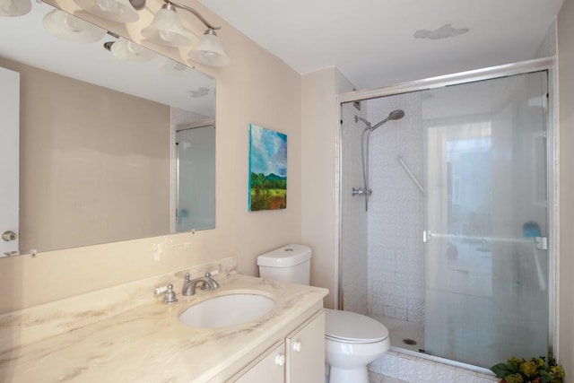 bathroom with vanity, a shower with shower door, and toilet