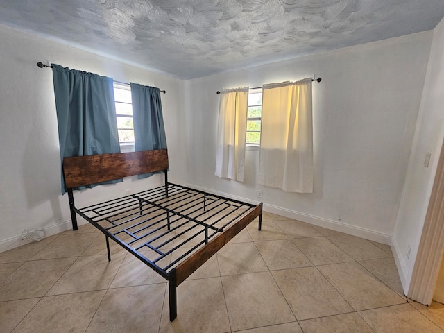 bedroom featuring multiple windows and light tile patterned flooring