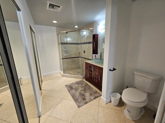 bathroom with tile patterned floors, vanity, toilet, and a shower with shower door