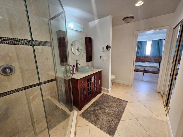 bathroom featuring tile patterned flooring, vanity, a shower with door, and toilet