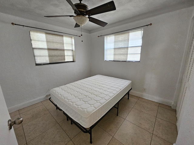 bedroom with ceiling fan and light tile patterned flooring