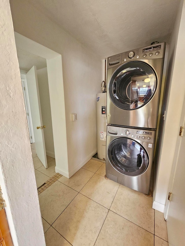 laundry room featuring light tile patterned flooring, stacked washer and clothes dryer, and water heater