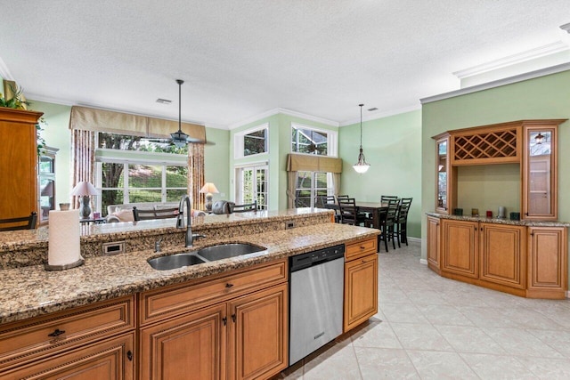 kitchen featuring sink, pendant lighting, dishwasher, and light stone countertops