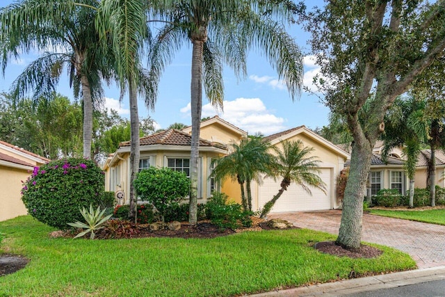 mediterranean / spanish-style house featuring a front yard and a garage