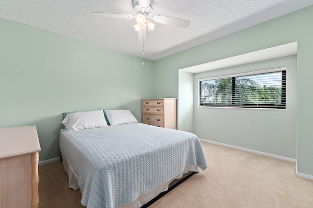 carpeted bedroom featuring baseboards, a ceiling fan, and a textured ceiling
