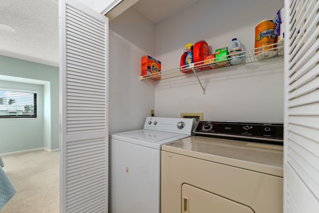 clothes washing area with laundry area, washer and clothes dryer, baseboards, and light carpet
