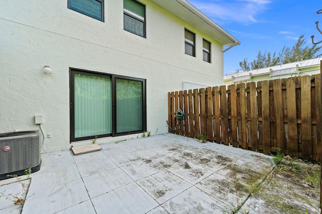 view of patio featuring central air condition unit and fence