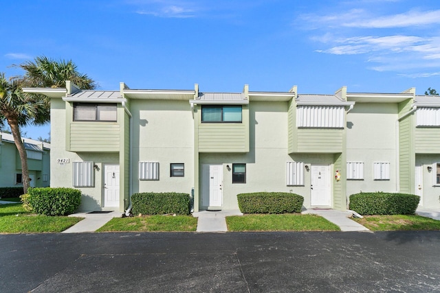 view of property with a standing seam roof, stucco siding, and metal roof
