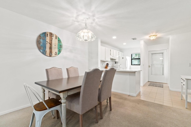 dining room with light carpet and an inviting chandelier