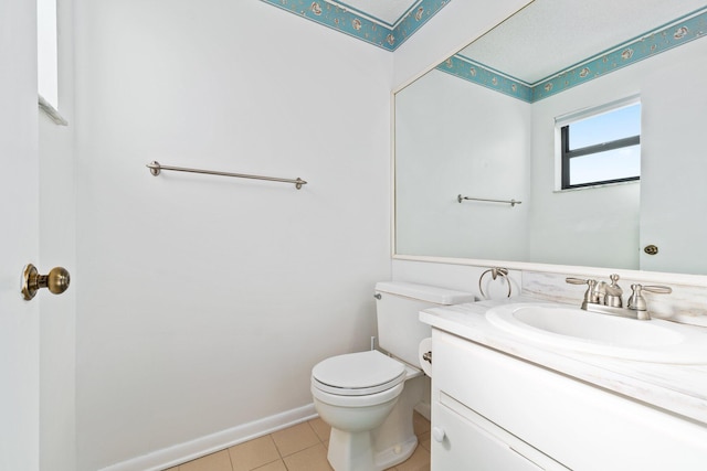 bathroom featuring vanity, baseboards, tile patterned flooring, and toilet