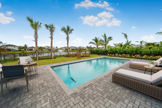 view of swimming pool with a water view, a yard, and a patio