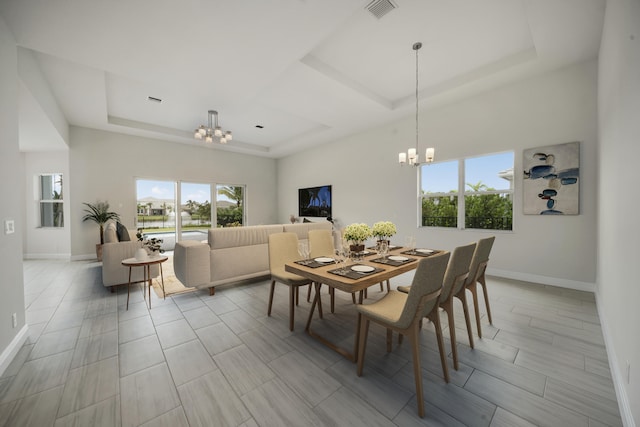 dining room featuring a notable chandelier and a tray ceiling