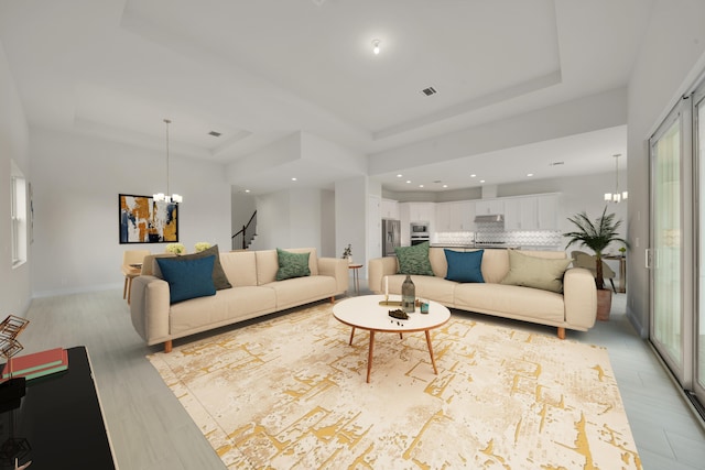 living room with light hardwood / wood-style flooring, an inviting chandelier, and a raised ceiling