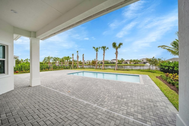 view of pool with a water view and a patio area