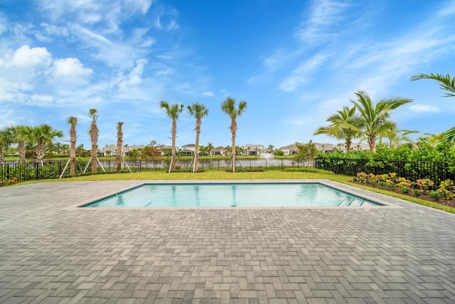 view of pool with a patio area and a water view