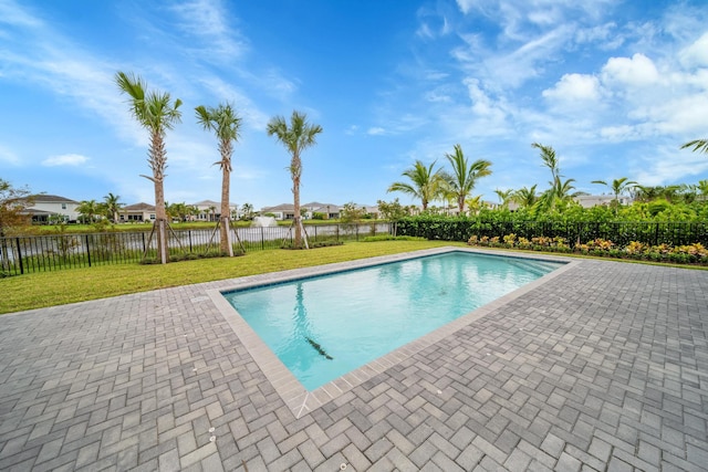 view of pool featuring a patio area, a lawn, and a water view