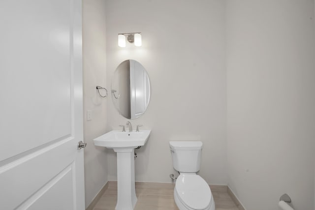 bathroom with hardwood / wood-style flooring and toilet